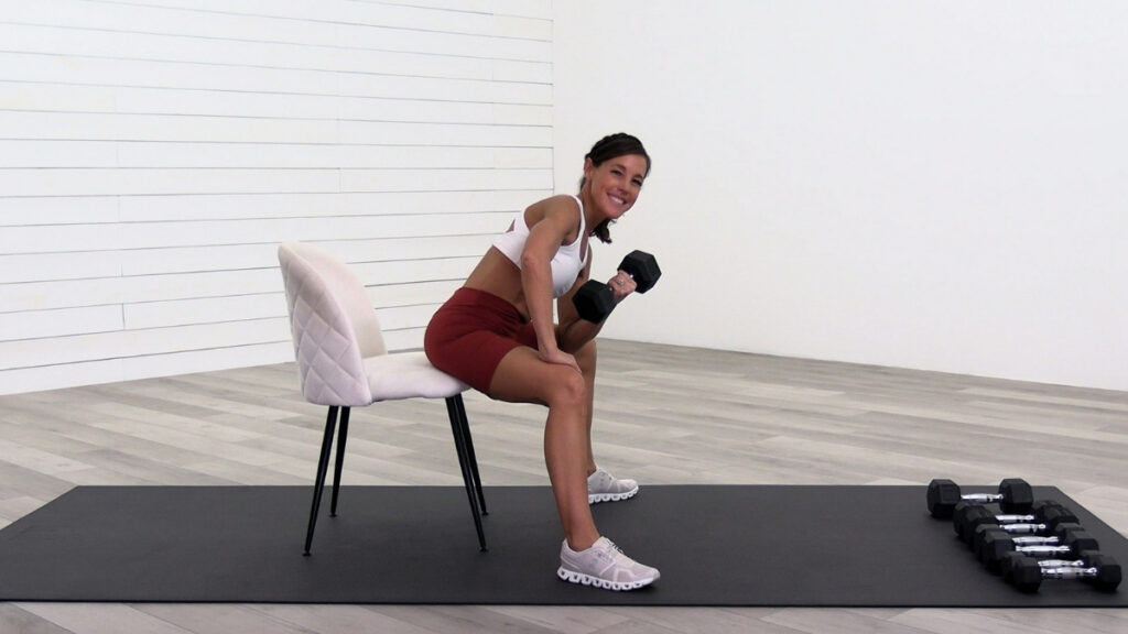 45 year old woman performing a concentration curl with dumbbell